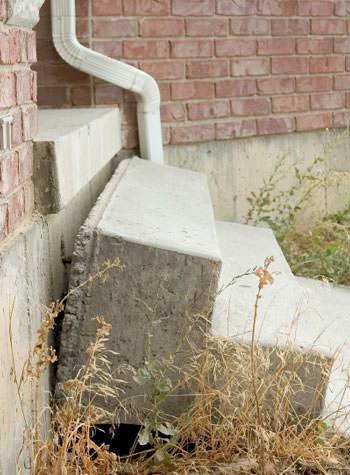 sinking outdoor concrete steps showing cracking and soil washout in Hermitage