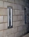 an inside view of foundation wall anchors installed along a basement wall to brace and repair the structure in Madison