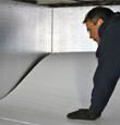 A contractor installing TerraBlock™ floor insulation in a Hopkinsville crawl space