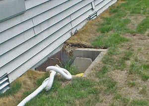 The ugly, old concrete window well of a Jackson crawl space