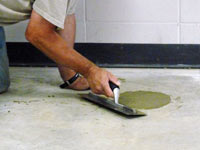 Repairing the cored holes in the concrete slab floor with fresh concrete and cleaning up the Smyrna home.
