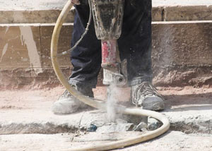 Jackhammering a slab floor in a Athens home.