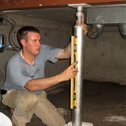 A contractor in Columbia installing a crawl space jack post.