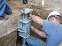 Foundation repair contractors installing the foundation bracket in Jackson.