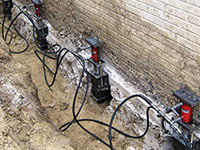Using foundation push piers to lift a foundation during a repair in Florence.