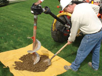 Auguring a hole in the earth for a foundation wall repair system in Smyrna