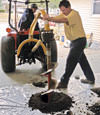 Digging a hole in the garage floor to make room for a wall anchor installation in Glasgow, Tennessee, Kentucky, and Alabama