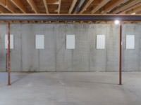 A repaired basement wall with foundation wall anchor covers installed in Athens.