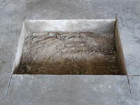 Creating the hole in the garage slab floor during the wall anchor installation in Tullahoma.