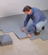 Contractors installing basement subfloor tiles and matting on a concrete basement floor in Bowling Green, Tennessee and Kentucky